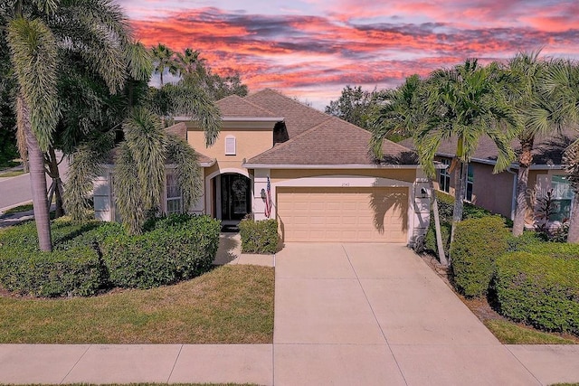2542 Cortenova Ct, Venice, FL 34292 - view of front facade featuring roof with shingles, driveway, a garage, and stucco siding