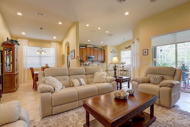 2542 Cortenova Ct, Venice, FL 34292 - living area featuring light tile patterned floors, an inviting chandelier, arched walkways, visible vents, and vaulted ceiling