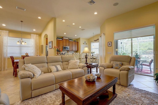 2542 Cortenova Ct, Venice, FL 34292 - living room with arched walkways, vaulted ceiling, visible vents, a chandelier, and light tile patterned flooring