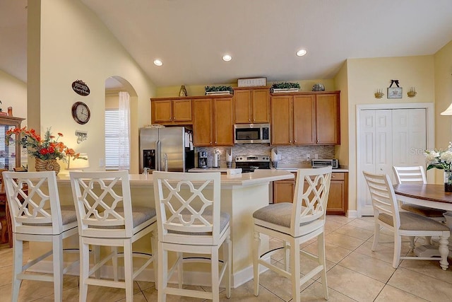 2542 Cortenova Ct, Venice, FL 34292 - kitchen featuring light countertops, a breakfast bar, arched walkways, and stainless steel appliances
