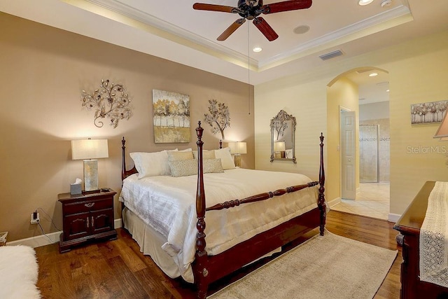 2542 Cortenova Ct, Venice, FL 34292 - bedroom featuring ornamental molding, a raised ceiling, arched walkways, and wood finished floors