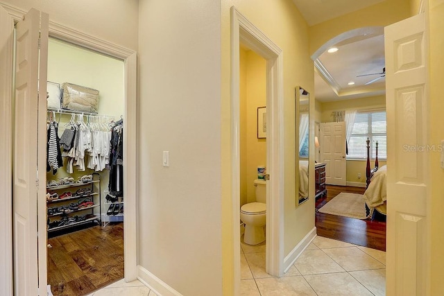 2542 Cortenova Ct, Venice, FL 34292 - hallway featuring arched walkways, light tile patterned floors, and baseboards