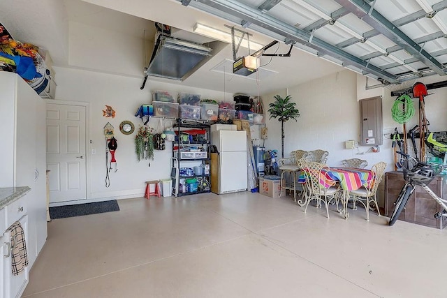 2542 Cortenova Ct, Venice, FL 34292 - garage featuring a garage door opener, freestanding refrigerator, and electric panel