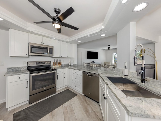 1232 Pine Needle Rd, Venice, FL 34285 - kitchen with a sink, ceiling fan, appliances with stainless steel finishes, a tray ceiling, and recessed lighting