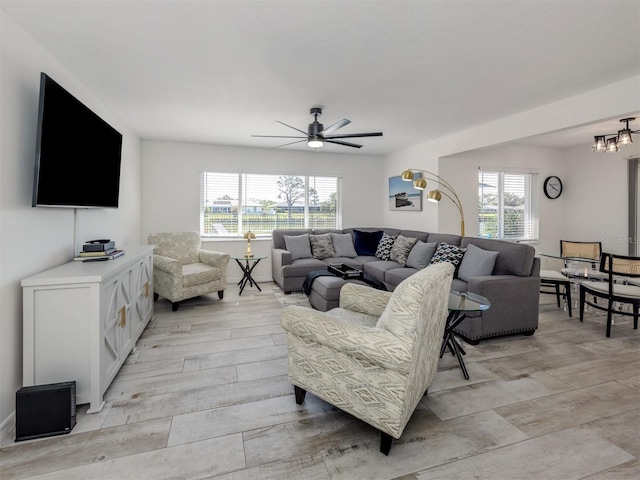 1232 Pine Needle Rd, Venice, FL 34285 - living room with a wealth of natural light, light wood-style flooring, and ceiling fan with notable chandelier