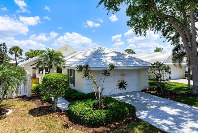 799 Harrington Lake Dr N Unit 73, Venice, FL 34293 - view of side of home featuring a tiled roof, an attached garage, driveway, and stucco siding