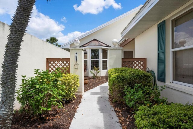 799 Harrington Lake Dr N Unit 73, Venice, FL 34293 - view of exterior entry with stucco siding and fence
