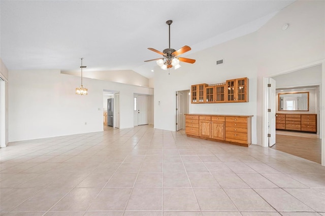 799 Harrington Lake Dr N Unit 73, Venice, FL 34293 - unfurnished living room featuring ceiling fan with notable chandelier, light tile patterned flooring, visible vents, and high vaulted ceiling