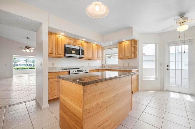 799 Harrington Lake Dr N Unit 73, Venice, FL 34293 - kitchen featuring light tile patterned floors, stove, a ceiling fan, a center island, and stainless steel microwave