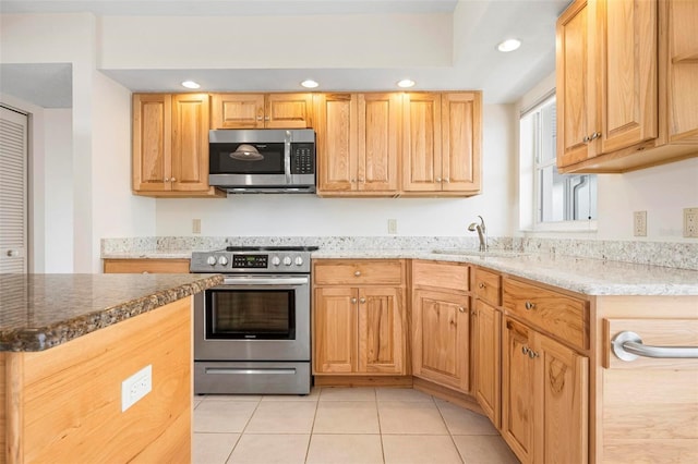 799 Harrington Lake Dr N Unit 73, Venice, FL 34293 - kitchen with light stone counters, recessed lighting, light tile patterned flooring, stainless steel appliances, and a sink