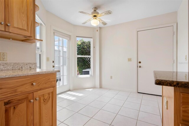 799 Harrington Lake Dr N Unit 73, Venice, FL 34293 - kitchen featuring light stone counters, ceiling fan, and light tile patterned floors