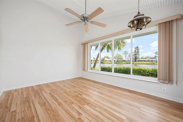799 Harrington Lake Dr N Unit 73, Venice, FL 34293 - unfurnished room featuring light wood-style flooring, ceiling fan with notable chandelier, baseboards, and a water view