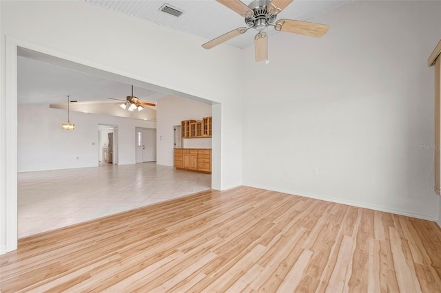 799 Harrington Lake Dr N Unit 73, Venice, FL 34293 - unfurnished living room with baseboards, vaulted ceiling, visible vents, ceiling fan, and wood finished floors