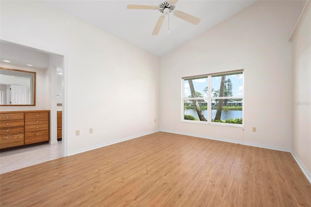 799 Harrington Lake Dr N Unit 73, Venice, FL 34293 - unfurnished bedroom featuring high vaulted ceiling, light wood-type flooring, a ceiling fan, a water view, and baseboards