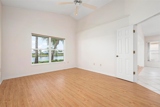 799 Harrington Lake Dr N Unit 73, Venice, FL 34293 - empty room featuring a water view, light wood-style floors, ceiling fan, and lofted ceiling