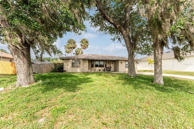 ranch-style house with a front yard, stucco siding, and fence