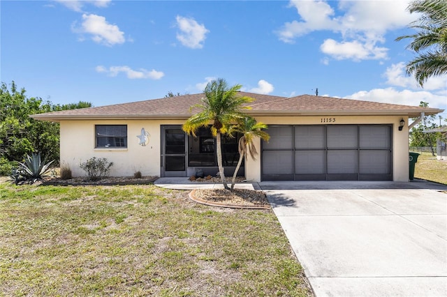 ranch-style house with concrete driveway, a front yard, an attached garage, and stucco siding