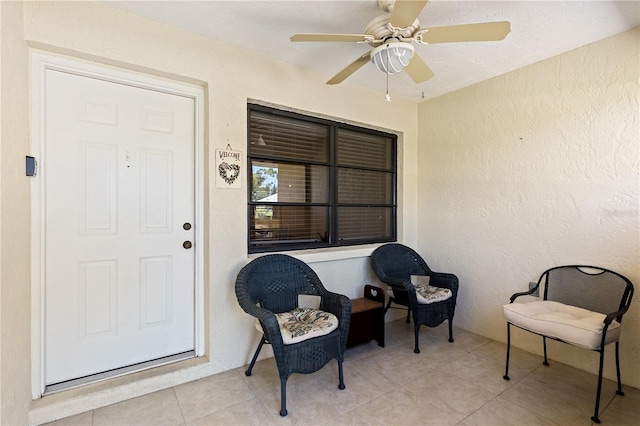 doorway to property featuring ceiling fan and stucco siding