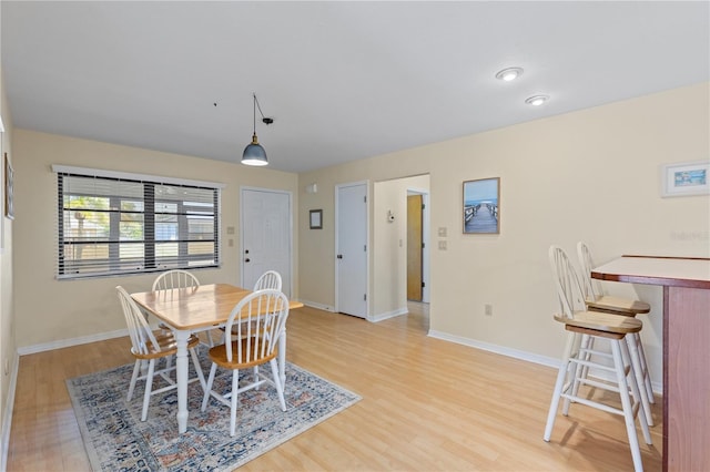 dining space with light wood finished floors and baseboards