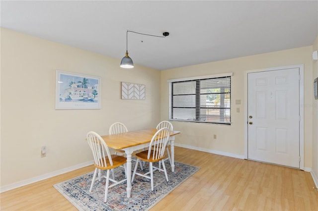dining space featuring light wood-style flooring and baseboards