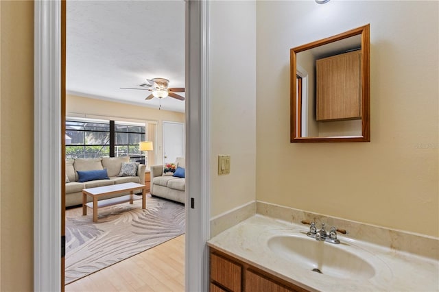 bathroom with wood finished floors, vanity, and a ceiling fan
