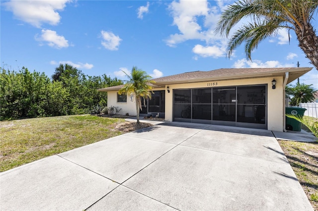 single story home featuring driveway, stucco siding, a front lawn, and a garage