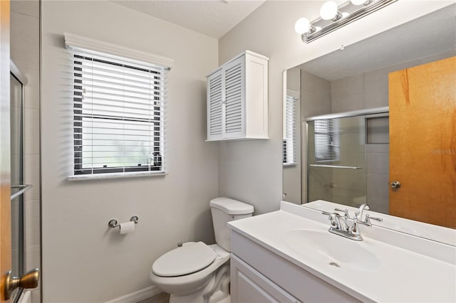 bathroom featuring vanity, baseboards, a tile shower, and toilet