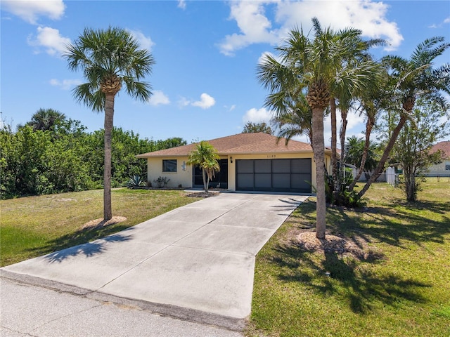 ranch-style home featuring a front yard, driveway, a garage, and stucco siding