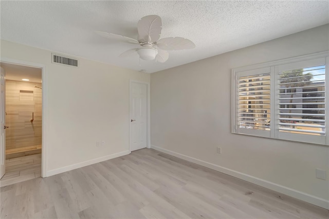 700 Golden Beach Blvd Unit 115, Venice, FL 34285 - unfurnished bedroom featuring light wood finished floors, baseboards, a textured ceiling, ensuite bath, and ceiling fan