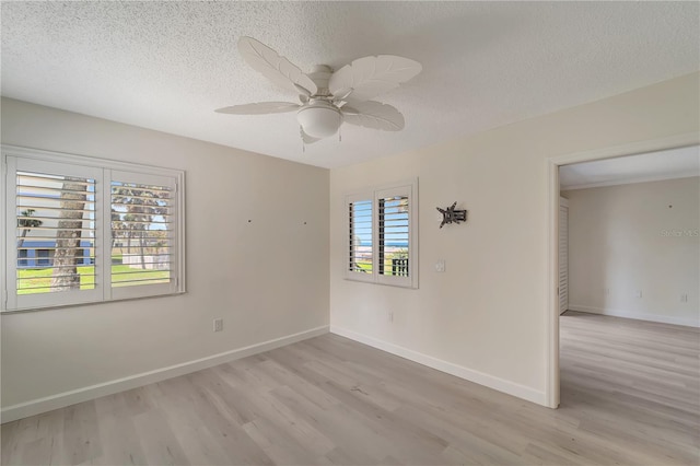 700 Golden Beach Blvd Unit 115, Venice, FL 34285 - unfurnished room featuring light wood finished floors, a textured ceiling, ceiling fan, and baseboards