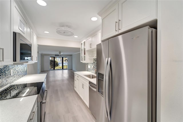 700 Golden Beach Blvd Unit 115, Venice, FL 34285 - kitchen with appliances with stainless steel finishes, light wood-type flooring, tasteful backsplash, white cabinets, and recessed lighting