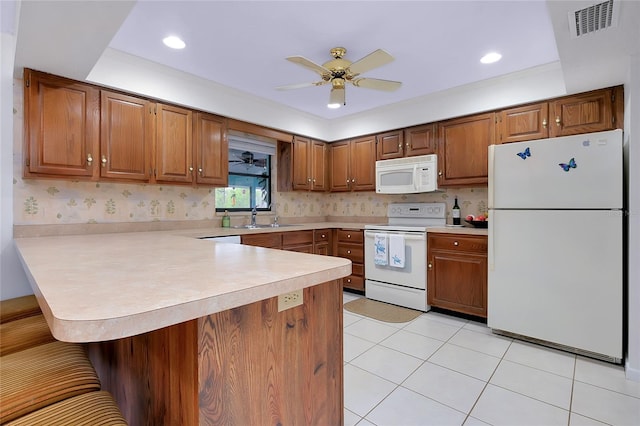 990 Sea Fox Rd, Venice, FL 34293 - kitchen featuring light countertops, a ceiling fan, white appliances, a peninsula, and a breakfast bar area