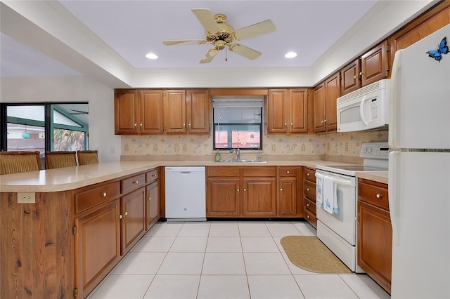 990 Sea Fox Rd, Venice, FL 34293 - kitchen featuring a sink, white appliances, a peninsula, and brown cabinets
