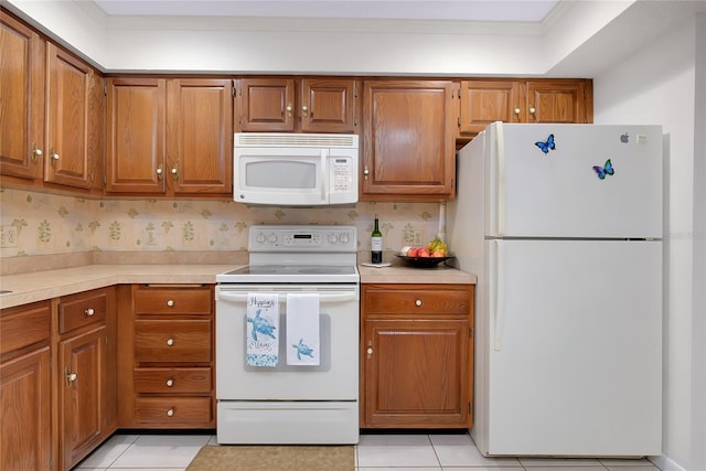990 Sea Fox Rd, Venice, FL 34293 - kitchen with light countertops, brown cabinetry, and white appliances