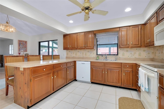 990 Sea Fox Rd, Venice, FL 34293 - kitchen featuring a sink, light countertops, white appliances, and a peninsula