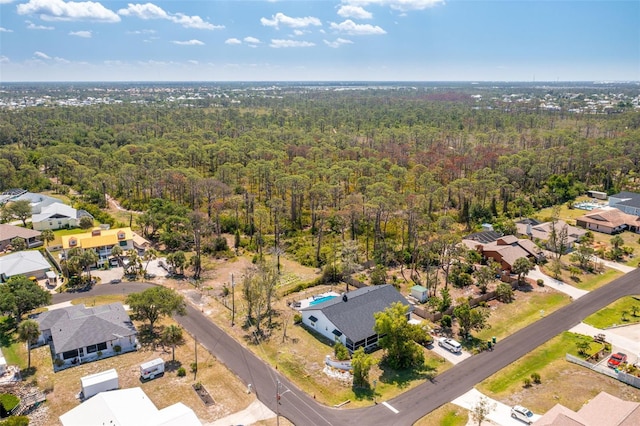 drone / aerial view with a wooded view and a residential view