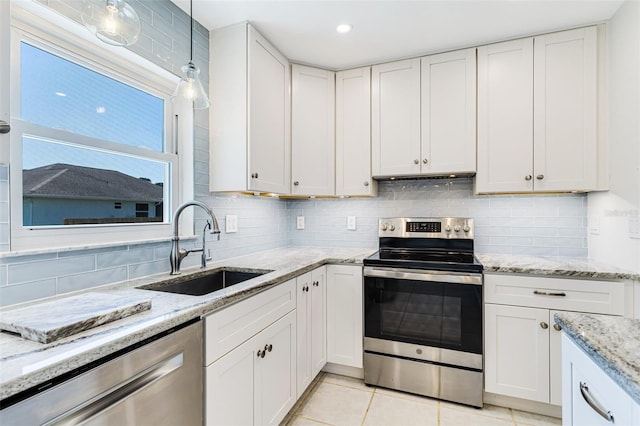 kitchen featuring a sink, backsplash, appliances with stainless steel finishes, and white cabinetry