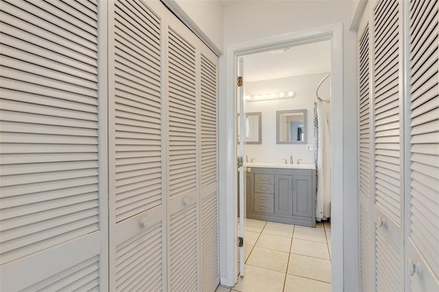 corridor with light tile patterned floors and a sink