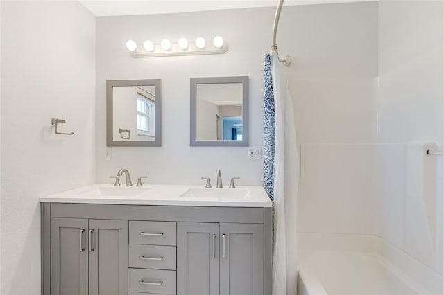 full bathroom with double vanity, a sink, and shower / tub combo