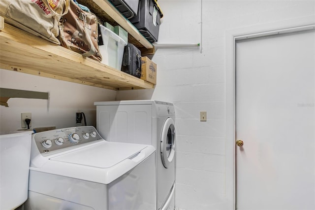 laundry area with washer and dryer, laundry area, and concrete block wall