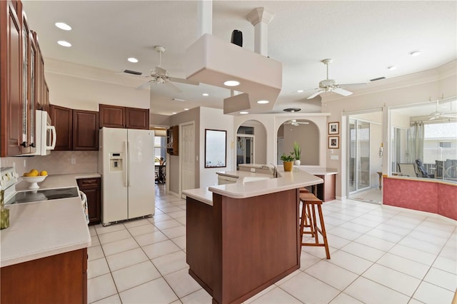 201 Bayside Ct, Nokomis, FL 34275 - kitchen with light countertops, a breakfast bar, ceiling fan, and white appliances
