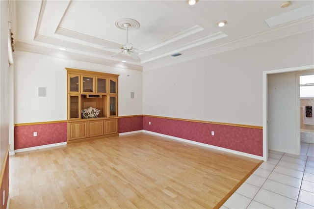 201 Bayside Ct, Nokomis, FL 34275 - empty room with a tray ceiling, crown molding, a ceiling fan, and wainscoting