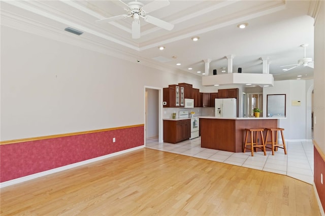 201 Bayside Ct, Nokomis, FL 34275 - kitchen with light countertops, visible vents, a ceiling fan, white appliances, and a breakfast bar area