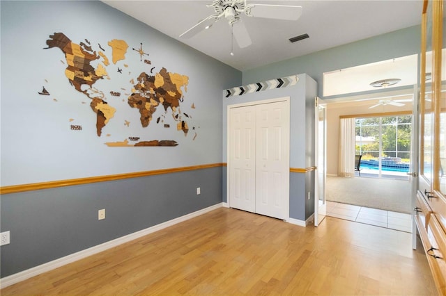 201 Bayside Ct, Nokomis, FL 34275 - unfurnished bedroom with access to exterior, visible vents, light wood-style floors, a ceiling fan, and a closet