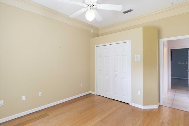 201 Bayside Ct, Nokomis, FL 34275 - unfurnished bedroom with crown molding, a closet, light wood finished floors, baseboards, and visible vents