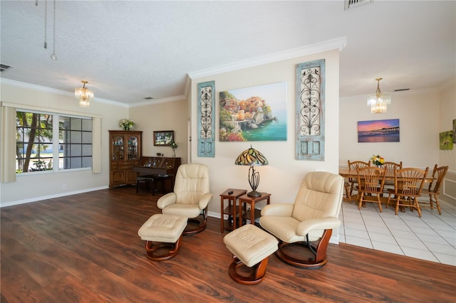 sitting room featuring an inviting chandelier, ornamental molding, and wood finished floors