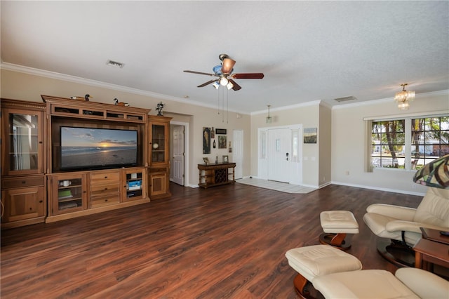 living room with visible vents, ornamental molding, ceiling fan with notable chandelier, and dark wood-style floors