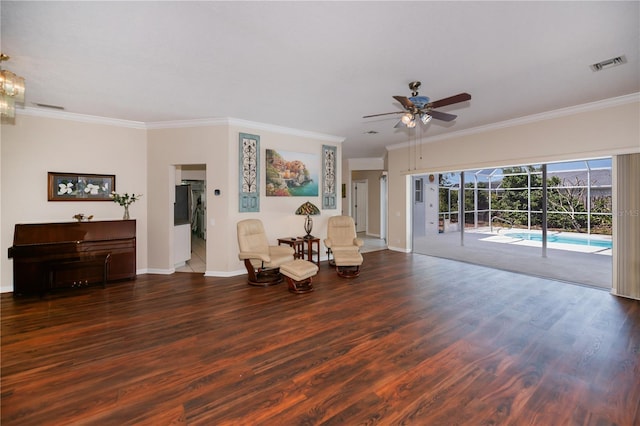 living area with visible vents, a ceiling fan, crown molding, and wood finished floors