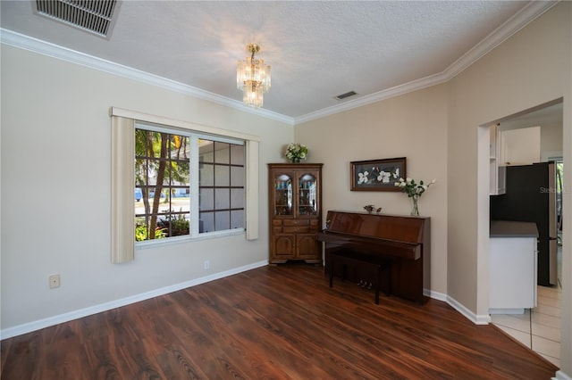 foyer featuring baseboards, a notable chandelier, wood finished floors, and visible vents