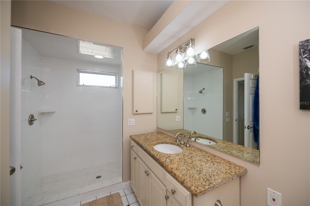 full bathroom with vanity, visible vents, and tiled shower